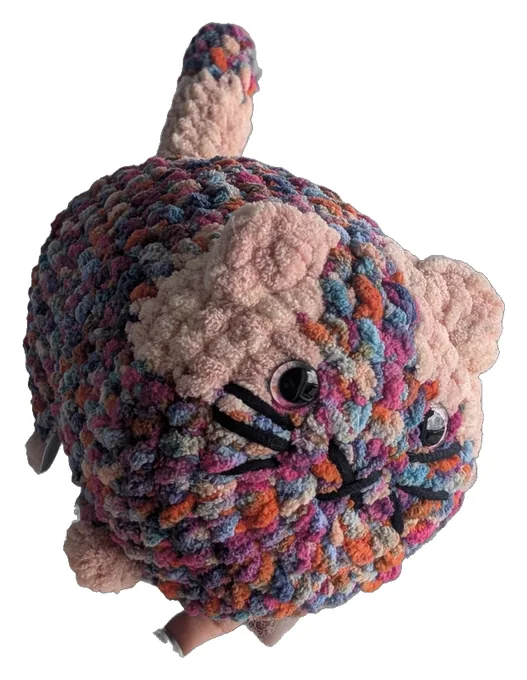 Round crochet cat in speckled rainbow yarn with peach ears and stitched whiskers