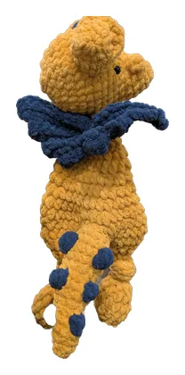Mustard-yellow crochet dinosaur with navy spikes and a scarf